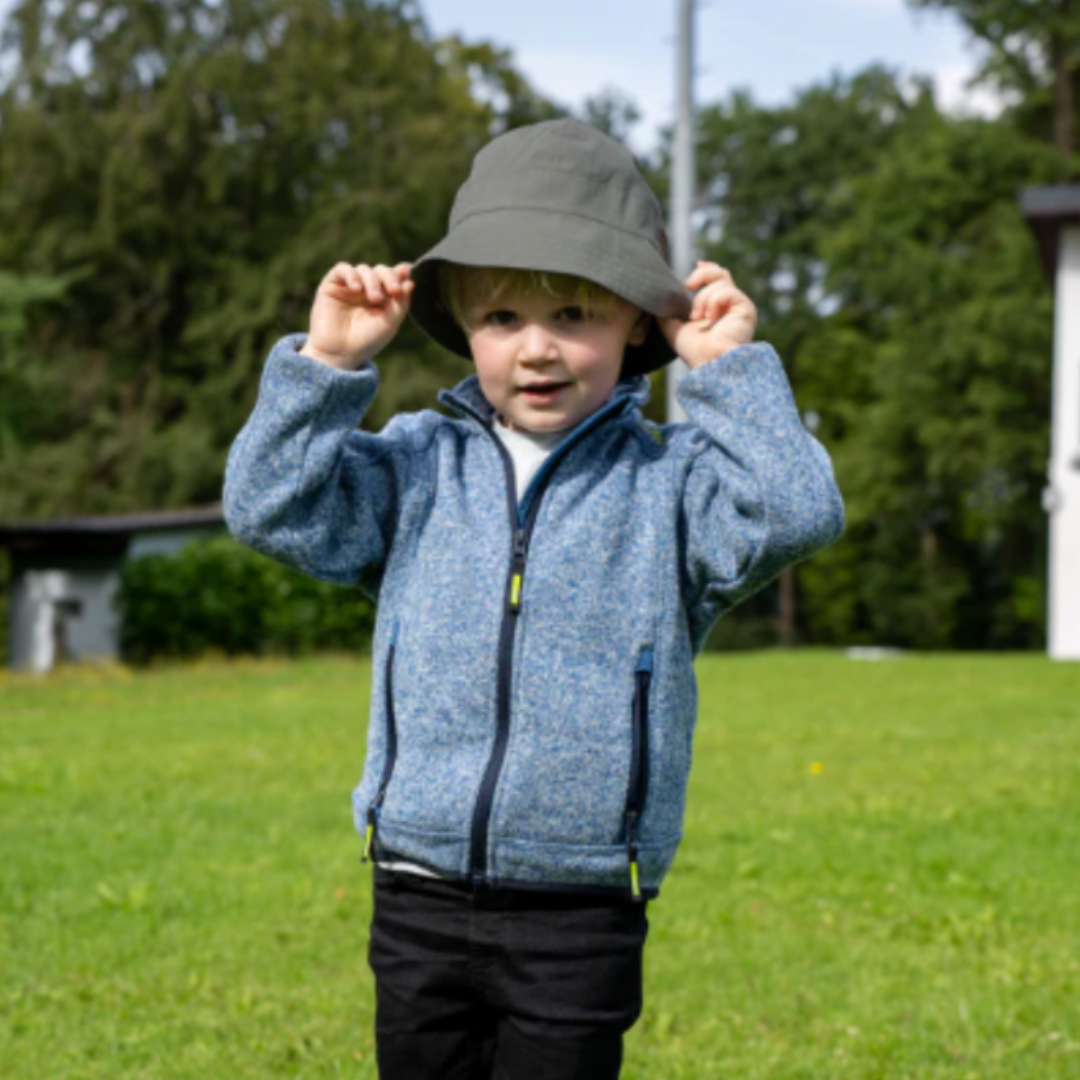 Cappello estivo Sterntaler bianco indossato da un bambin all'aperto per una protezione ottimale.
