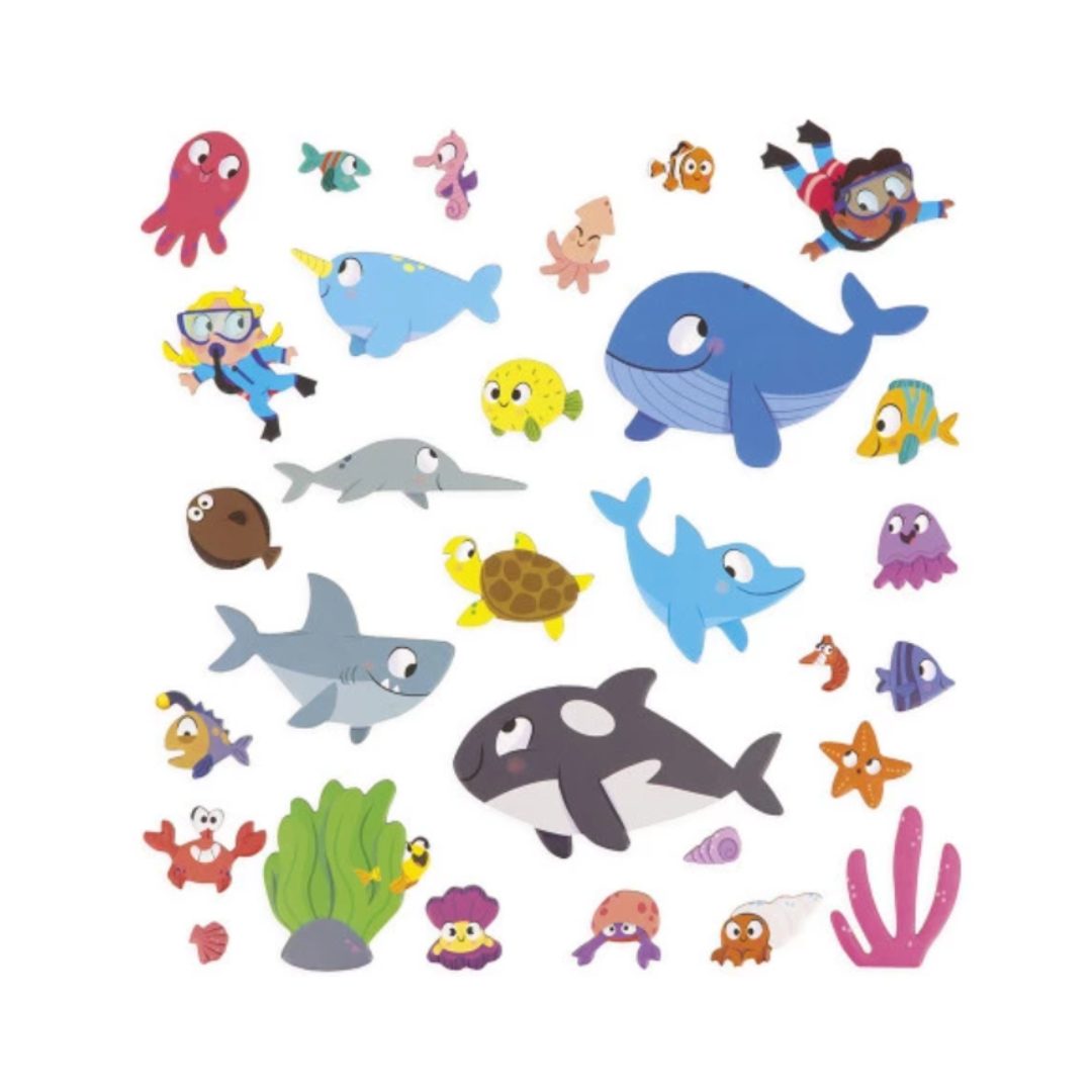Set completo di 30 magneti a tema marino del gioco Janod Magneti’Stories, con pesci, balene, sub e coralli colorati.