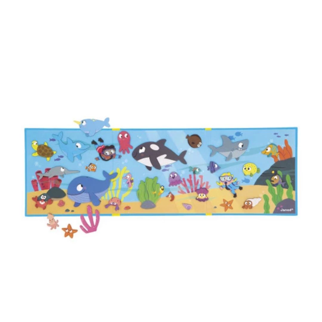 Gioco Magneti’Stories Janod aperto, con sfondo magnetico marino e animali applicati, stimola la fantasia e la narrazione nei bambini.