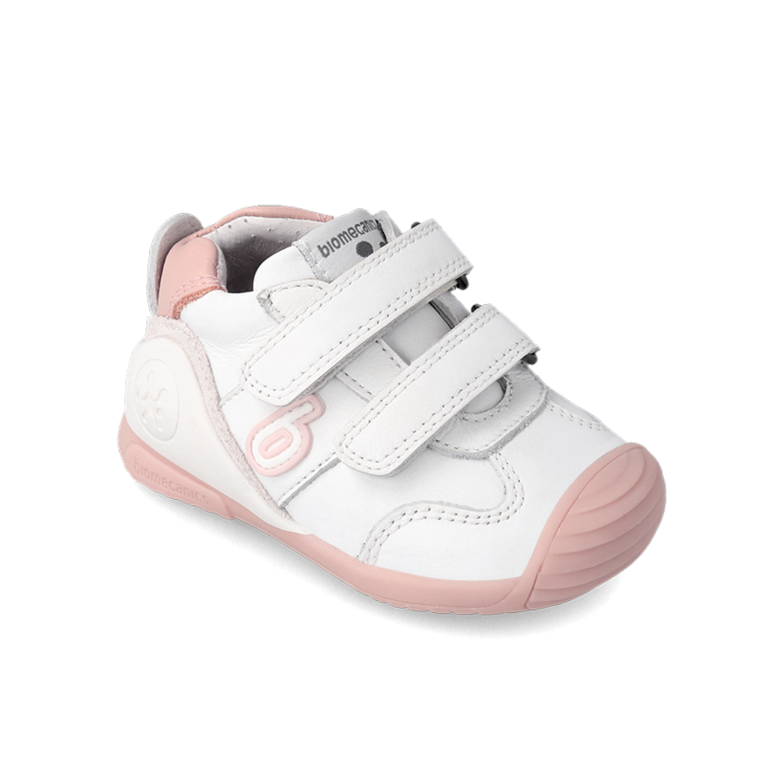 Scarpe da bambina Biomecanics bianche con dettagli rosa e puntale rinforzato per protezione extra.