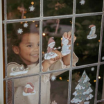 Bambina posiziona adesivi natalizi di Little Dutch su una finestra