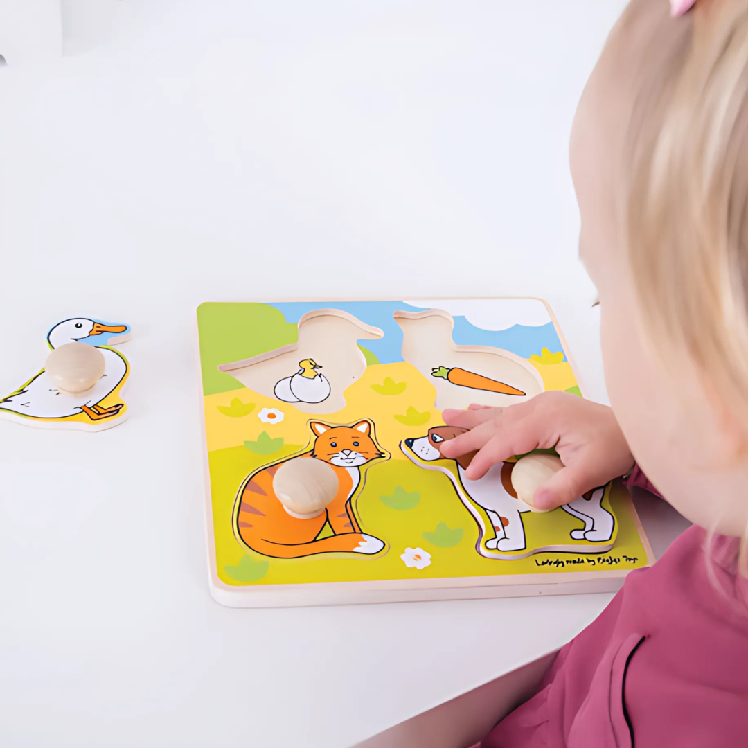Bambina che gioca con il puzzle Bigjigs in legno con pomelli e animali domestici