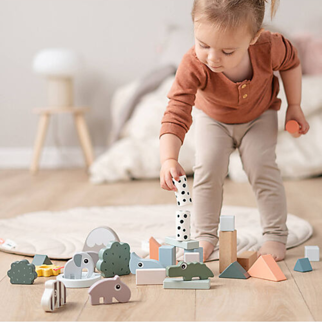 Bambina che gioca con il Set Costruzioni di Legno Deer Friends, migliorando coordinazione e motricità fine.