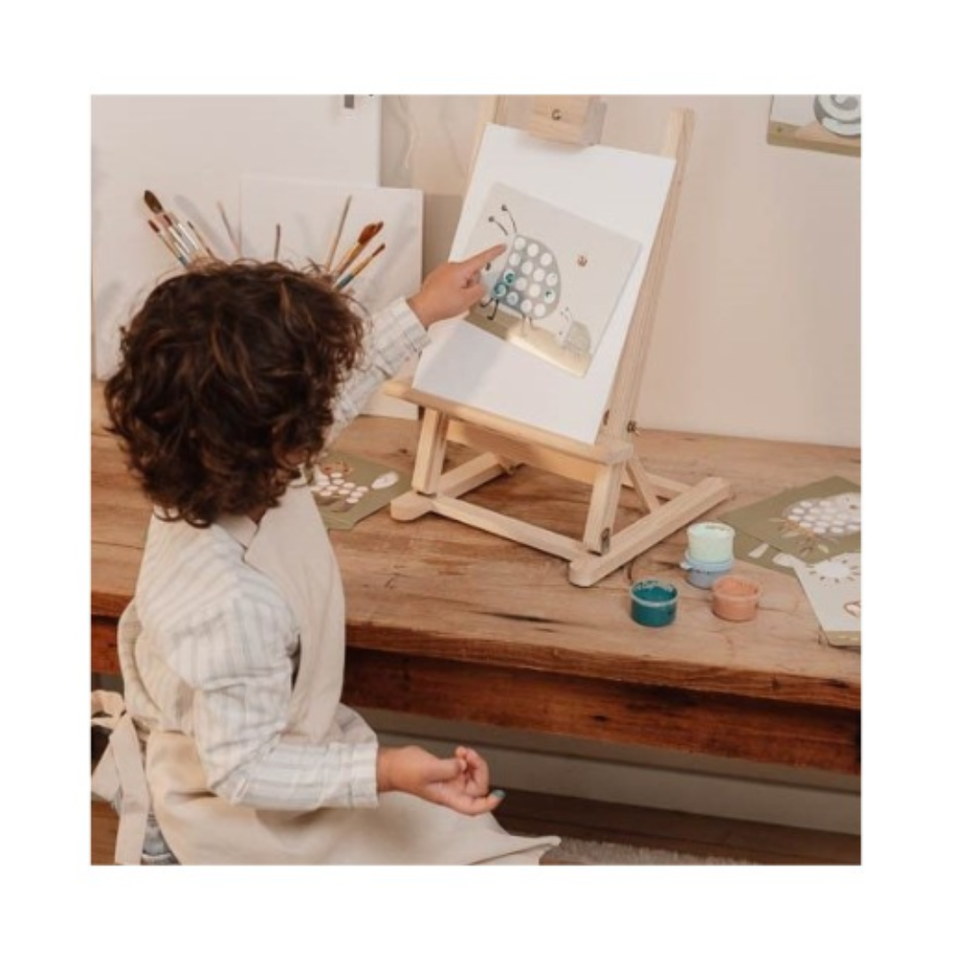 Bambino che dipinge con le dita su un cavalletto usando le schede del set Forest Friends

