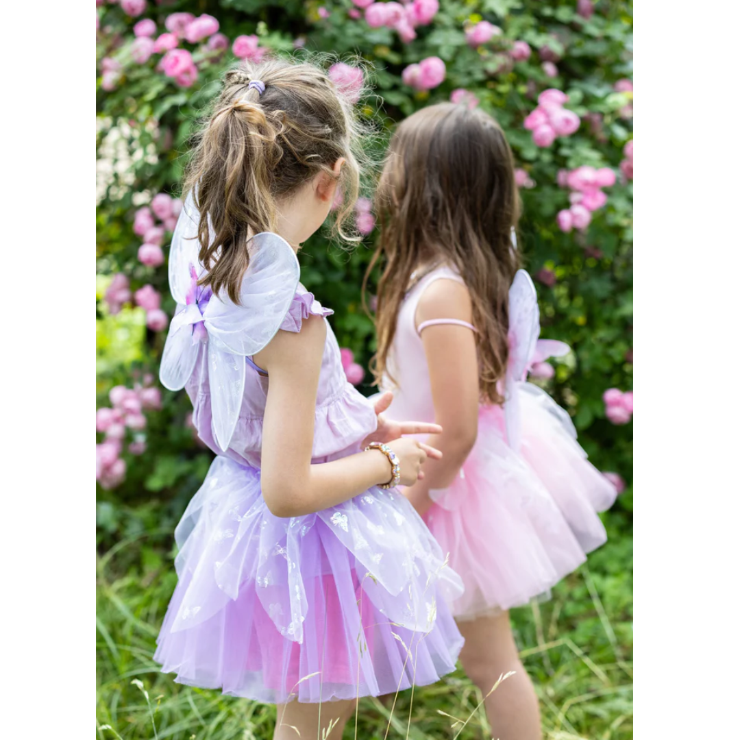 Due bambine che indossano il costume rosa e viola in un prato fiorito.