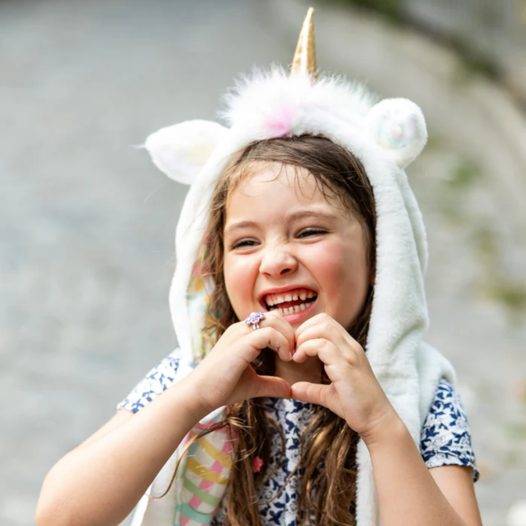 Bambina felice con Vestito Unicorno Great Pretenders bianco effetto peluche, perfetto per giochi e travestimenti magici