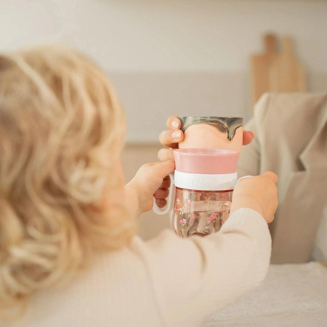 Bambino con il bicchiere Trainer 360° Mepal Little Dutch in mano