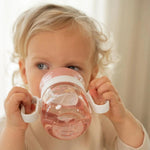 Bambino che beve con due mani dal bicchiere Trainer 360° Little Dutch