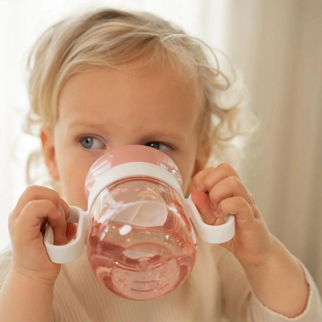 Bambino che beve con due mani dal bicchiere Trainer 360° Little Dutch