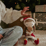 Mano di bambina che sistema l'Elfa Rosa Little Dutch tra i regali di Natale