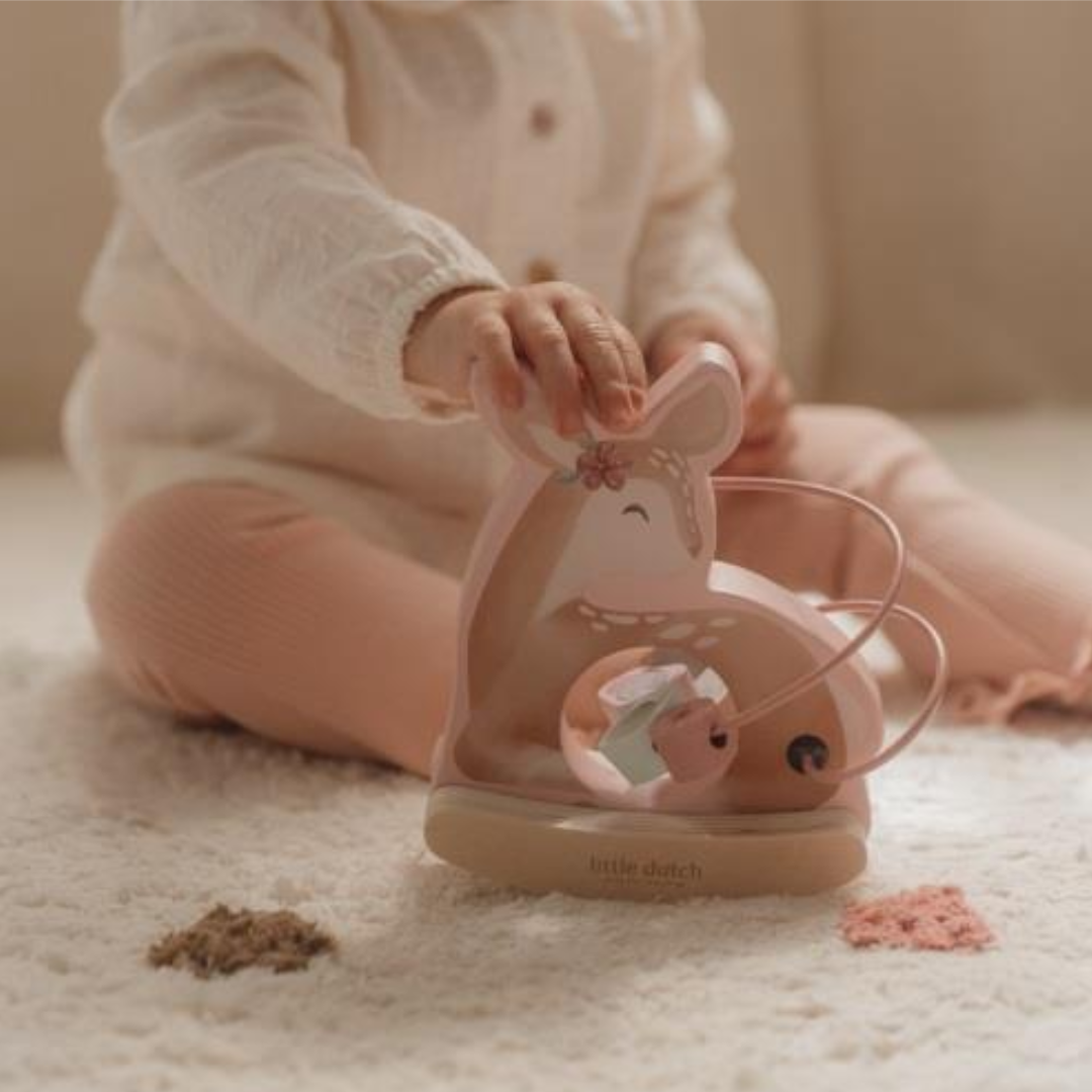 Bambina che gioca con il Little Dutch Rocking Deer, un gioco multiattività in legno della collezione Fairy Garden, ideale per bambine di 1 anno.