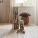 Set completo di cubi da costruzione in cartone rinforzato sparsi a terra per gioco libero e creativo