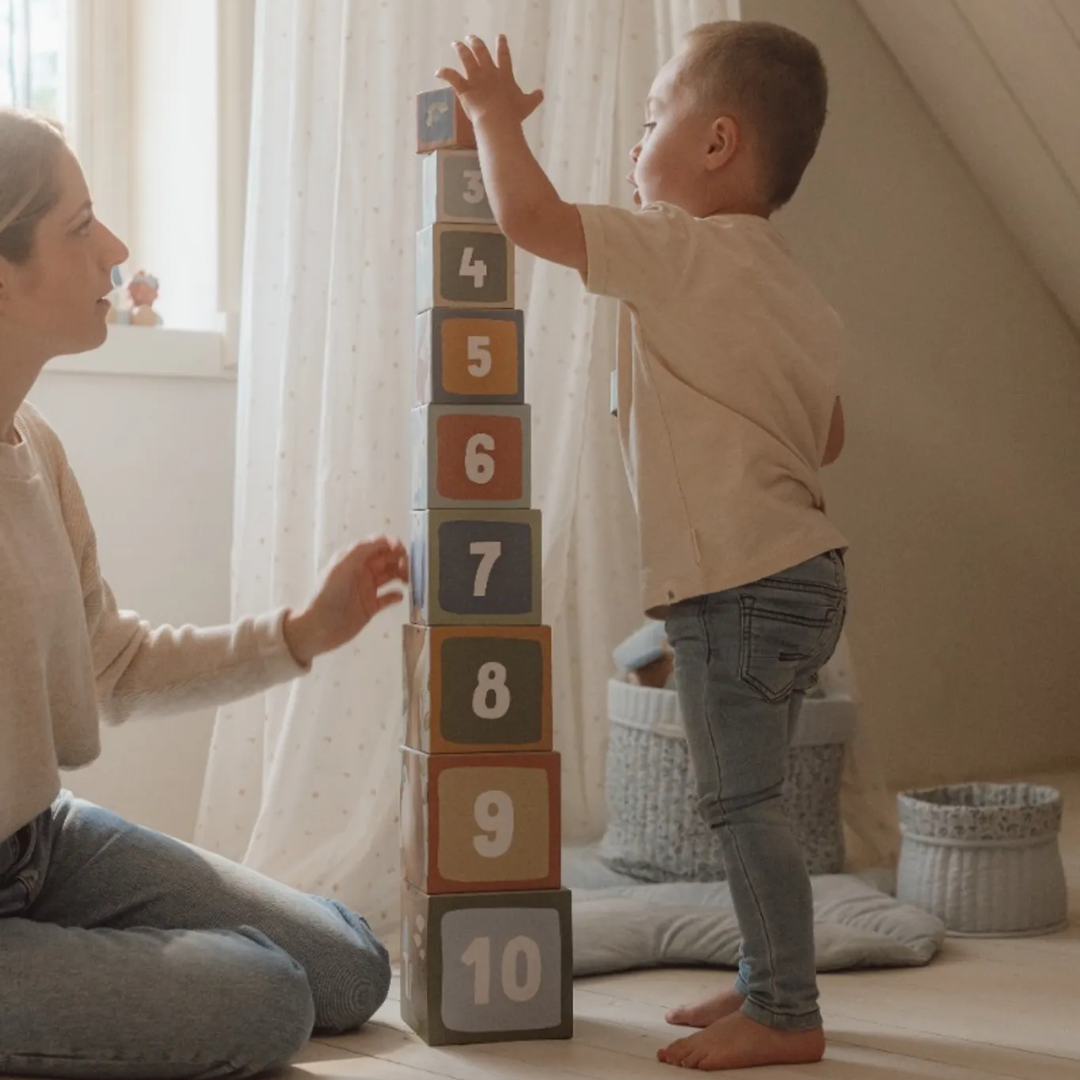Bambino di 18 mesi che allena la motricità fine impilando i cubi educativi Little Dutch